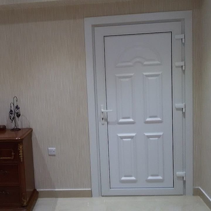White uPVC panelled door with arched top panel installed in a villa interior in Abu Dhabi by A R Aluminium and Glass